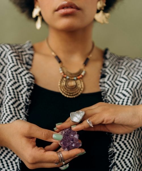 Mujer sosteniendo una piedra de amatista en su mano